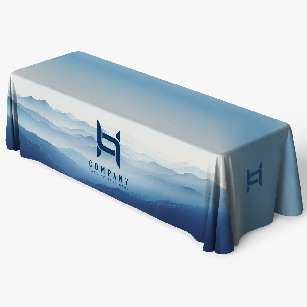 Custom printed 8ft fitted table cover featuring a full-bleed blue mountain landscape design and a white company logo on the front panel, produced by 760 Print in Vista.