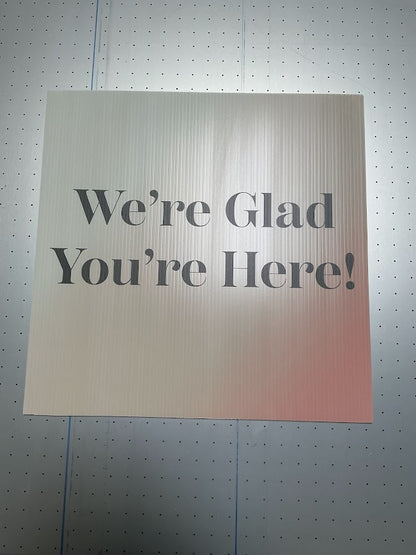 Custom printed large format printed coroplast sheet with the words 'We're Glad You're Here' being manufactured on a printing bed by 760 Print in Vista.