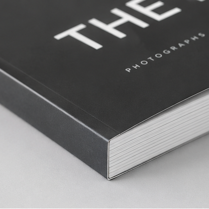 Close-up detail of a custom printed black softcover book spine and perfect bound edges for 'The Photographs', showcasing high-quality commercial book binding by 760 Print in Vista.