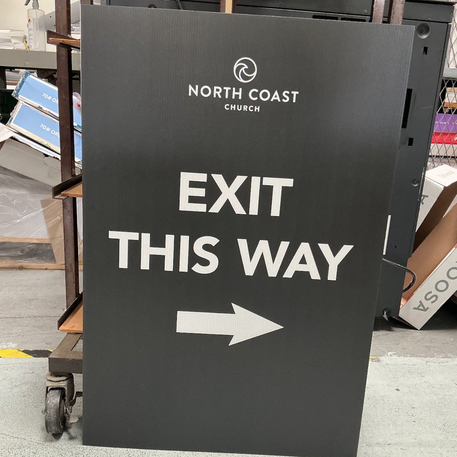 Stack of custom print and cut coroplast inserts for an A-frame Signicade sign at 760 Print in Vista, featuring a high-quality 'EXIT THIS WAY' directional design with the North Coast Church logo.